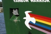 PIcture of the hull of the Rainbow Warrior, with a rainbow and dove painted across its bow.